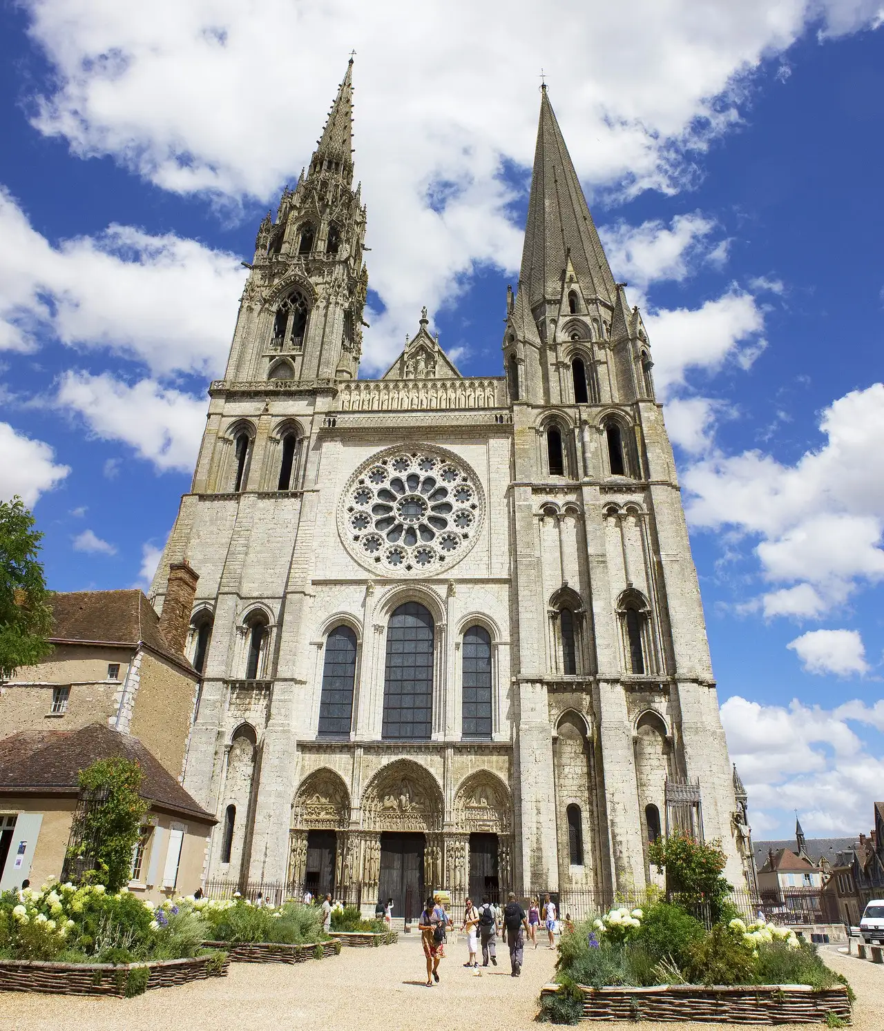 The west front of Chartres Cathedral with its two contrasting spires, west rose window, and Royal Portal.