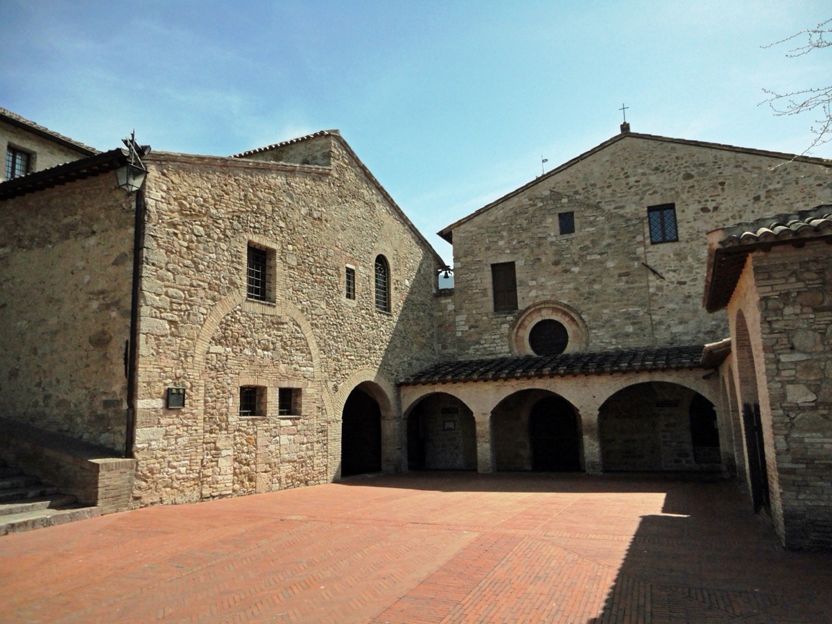 The stone church and portico of San Damiano below the walls of Assisi.
