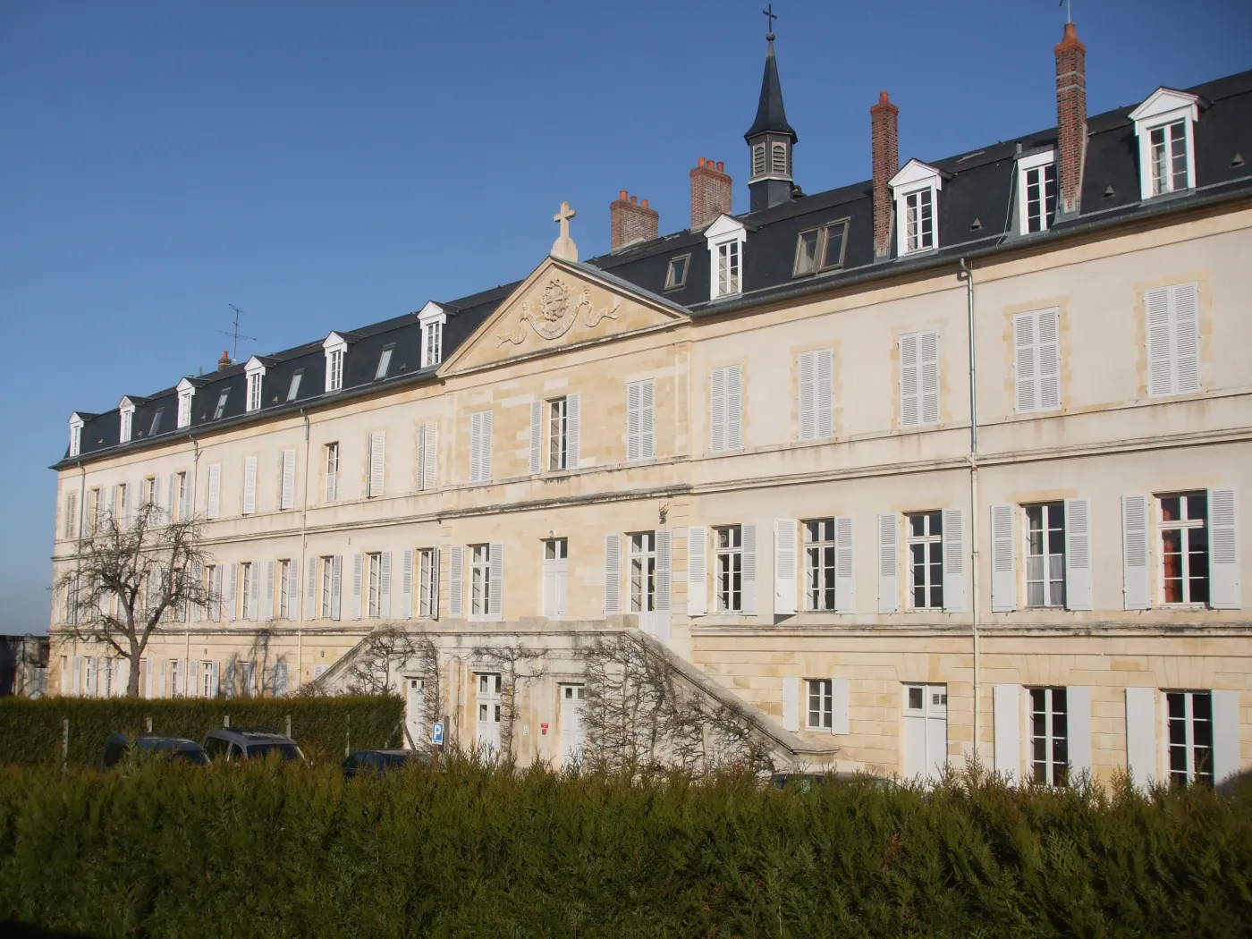 The stone convent of Saint-Gildard at Nevers under a clear sky.