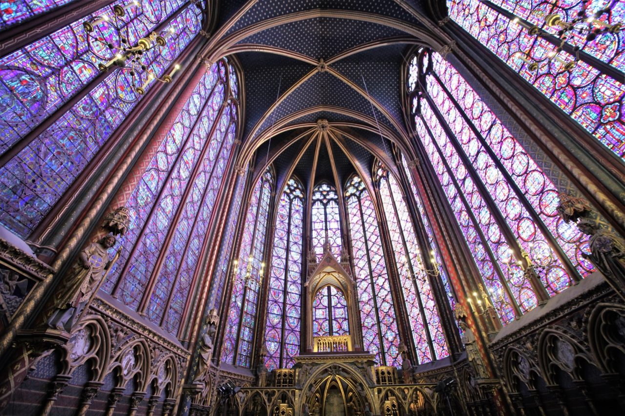 The stained glass windows and vaulted apse of the upper chapel of the Sainte-Chapelle in Paris.