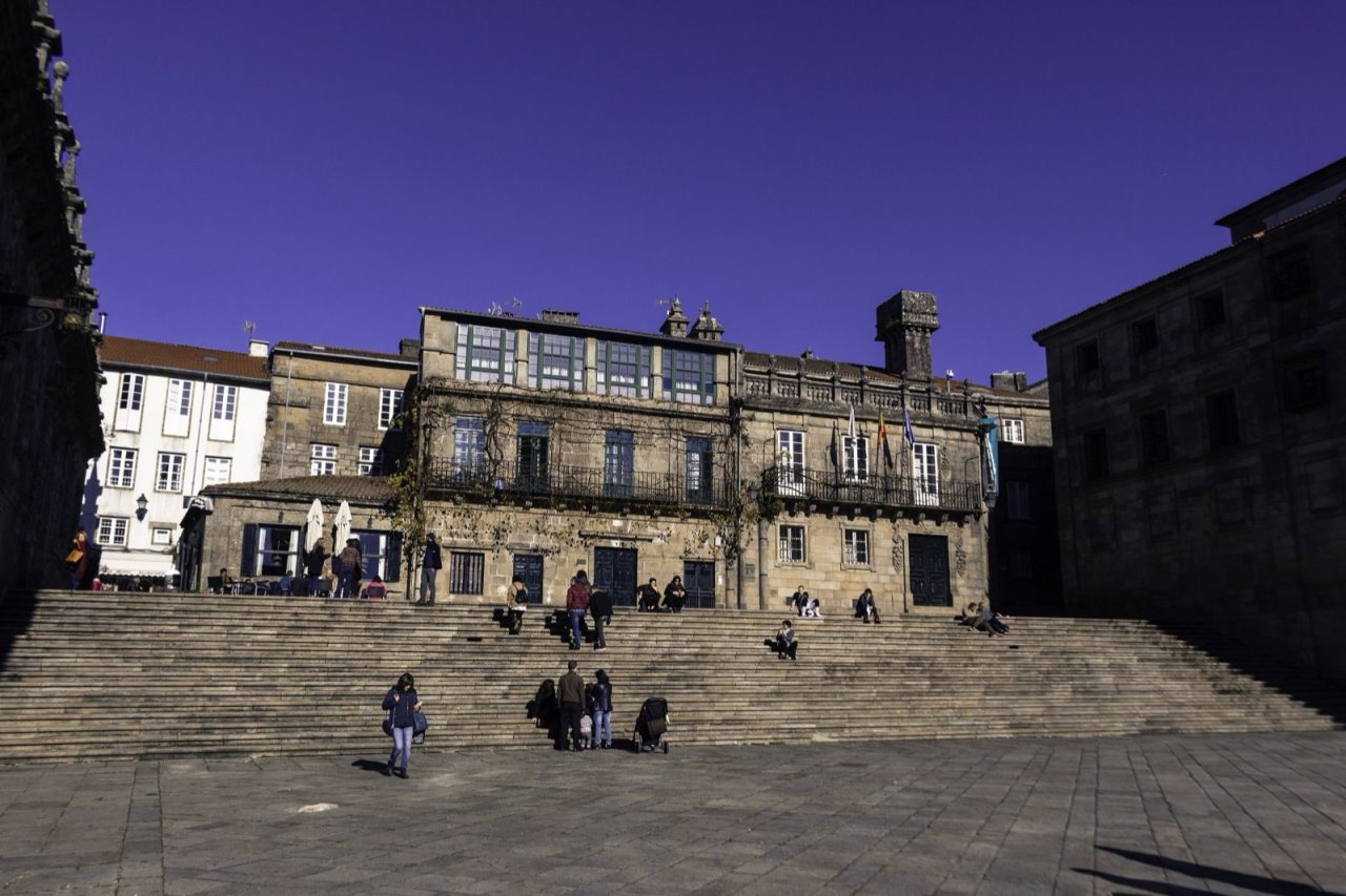 The Praza da Quintana in Santiago de Compostela, its broad flight of granite steps rising toward the long blank wall of the San Paio monastery.