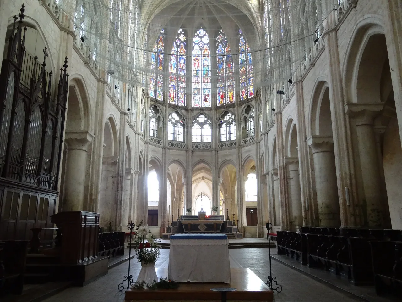 The choir of Église Saint-Pierre in Chartres seen down the nave, its tall windows filled with figures of the Old Testament above the altar.