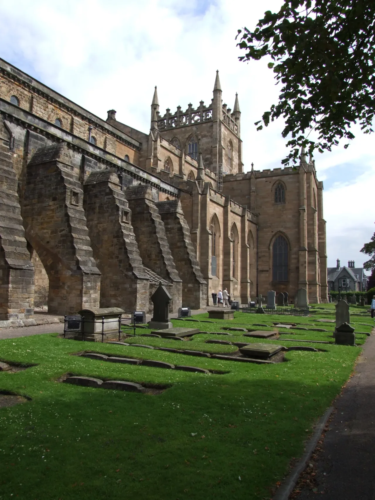 The stone nave and church of Dunfermline Abbey seen from the surrounding grounds.