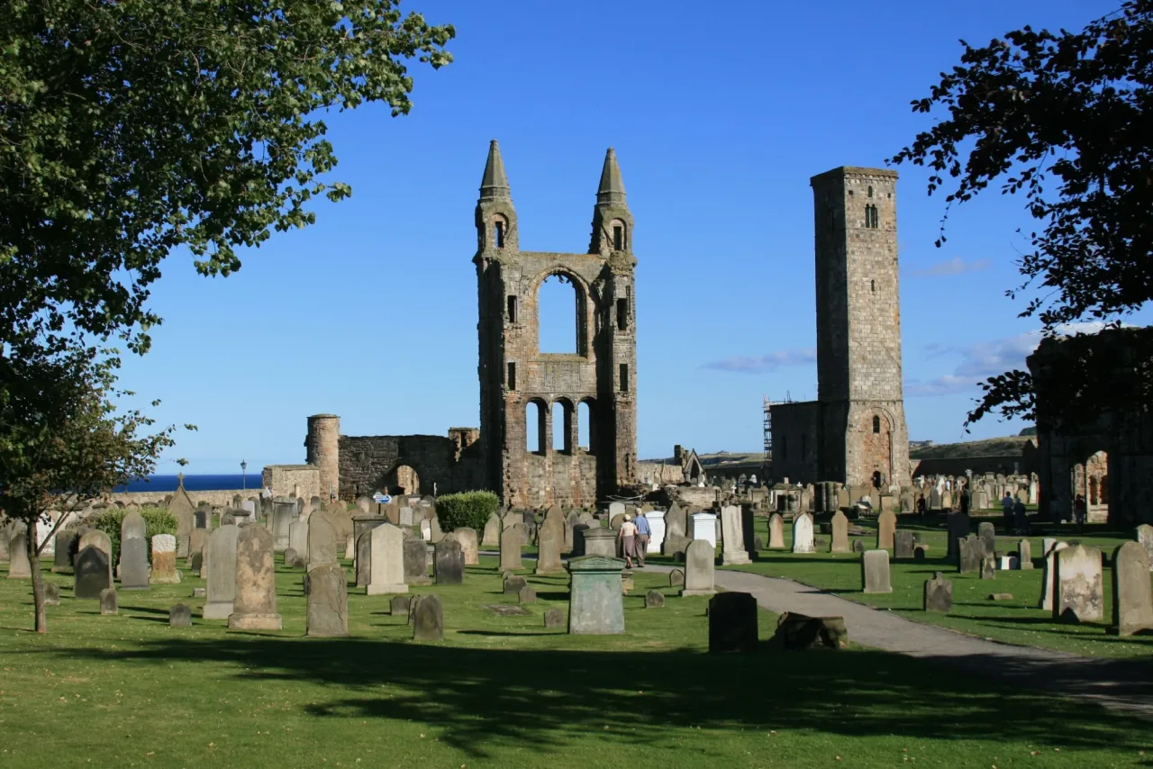 The east gable and St Rule's Tower rising above the graveyard at St Andrews Cathedral, with the sea beyond.