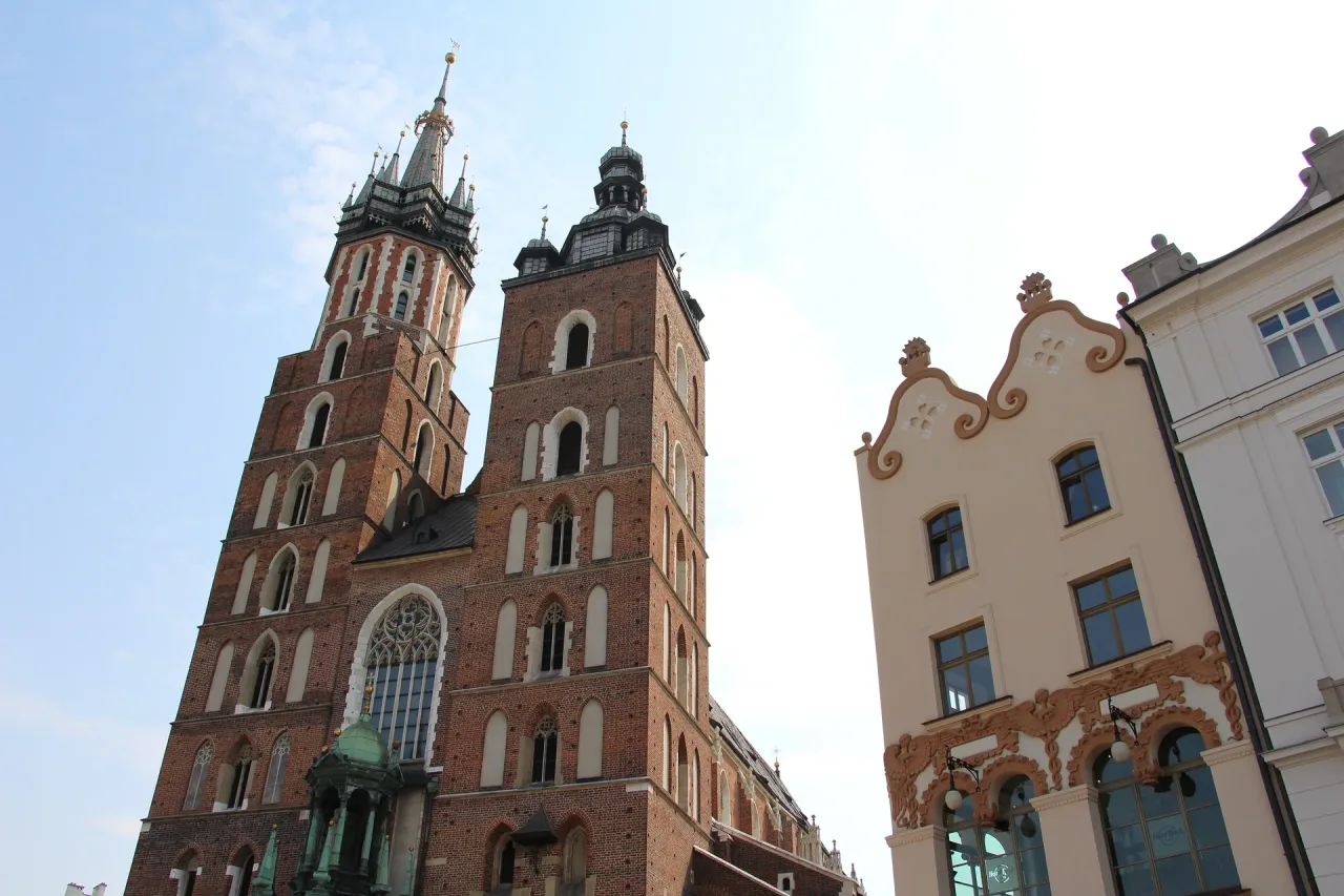The two unequal brick towers of St. Mary's Basilica in Kraków rising over the Main Market Square.