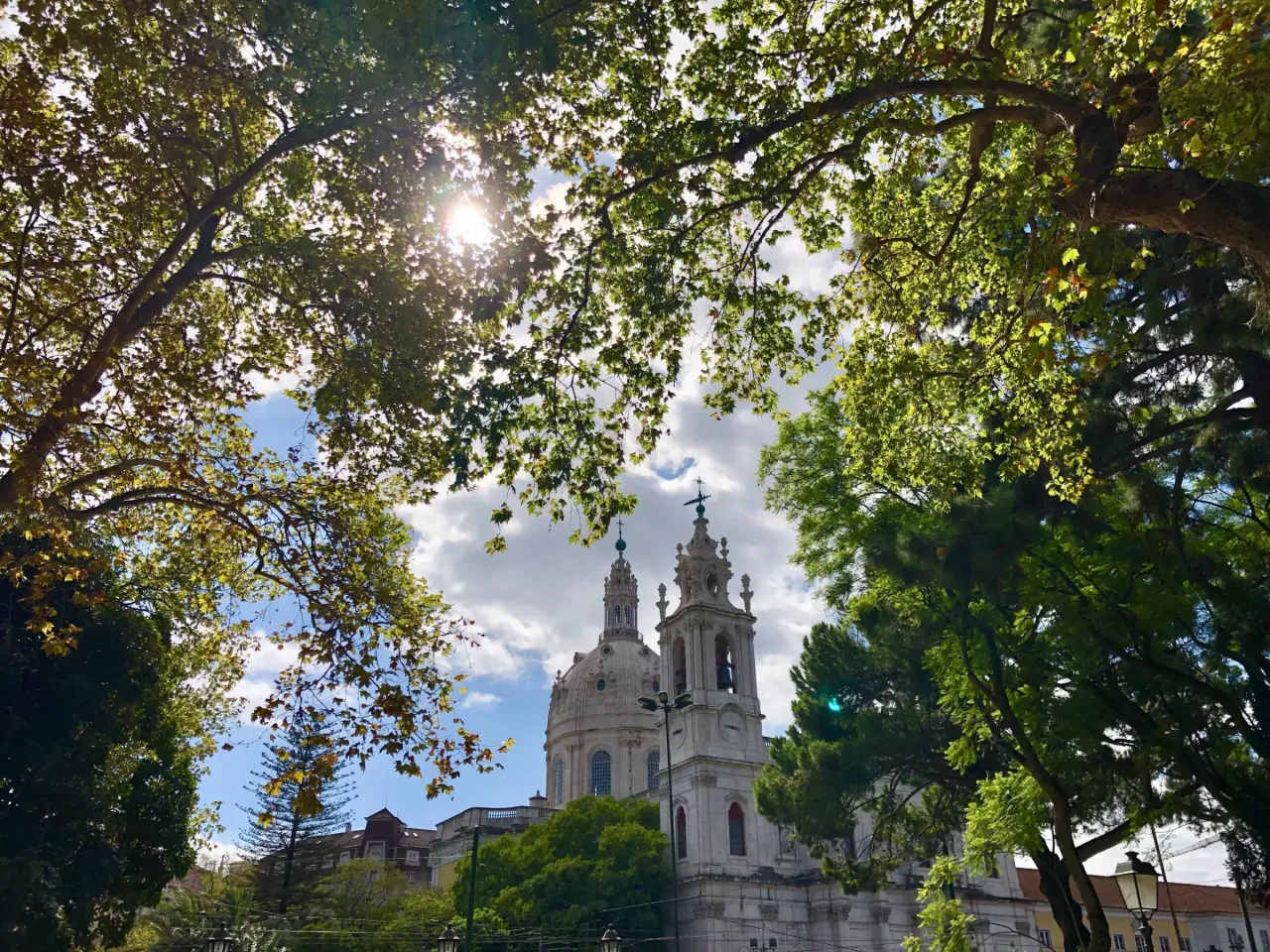 The dome and twin bell towers of the Estrela Basilica seen through the trees of the Jardim da Estrela opposite.