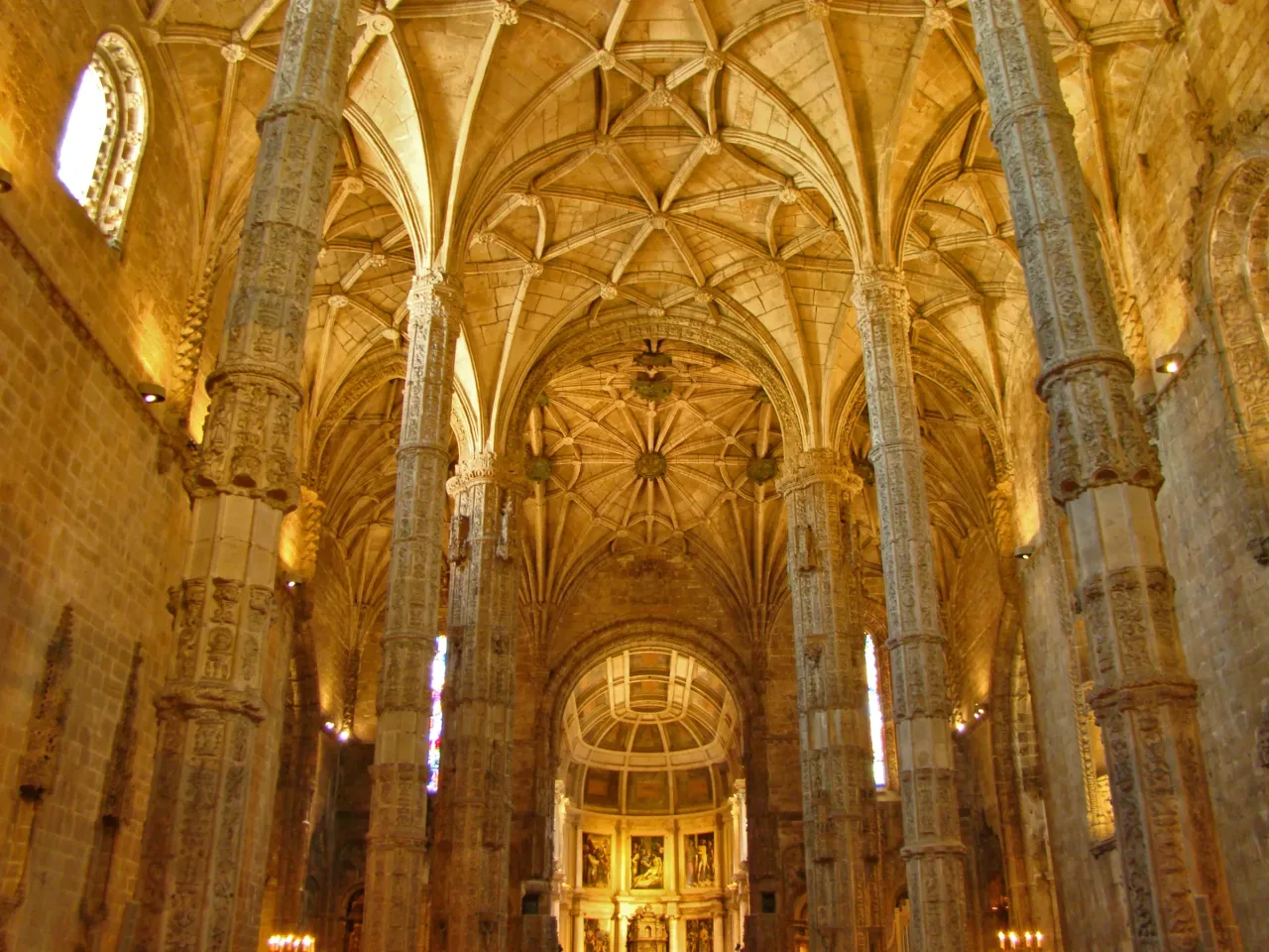 The interior of the church of Santa Maria de Belém, where slender octagonal piers rise into a wide net-vaulted ceiling.