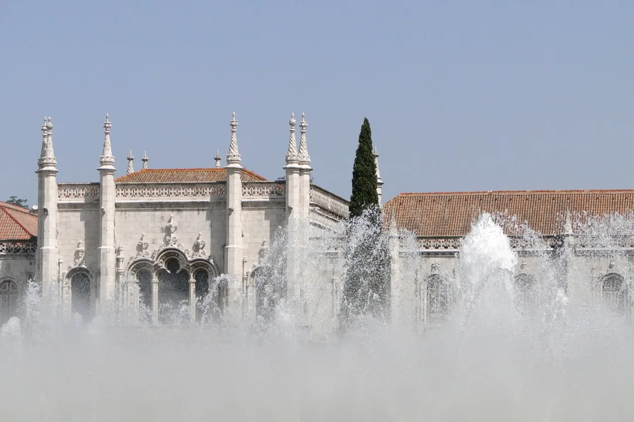 The long Manueline south range of the Jerónimos Monastery seen across the fountains of the Praça do Império in Belém.