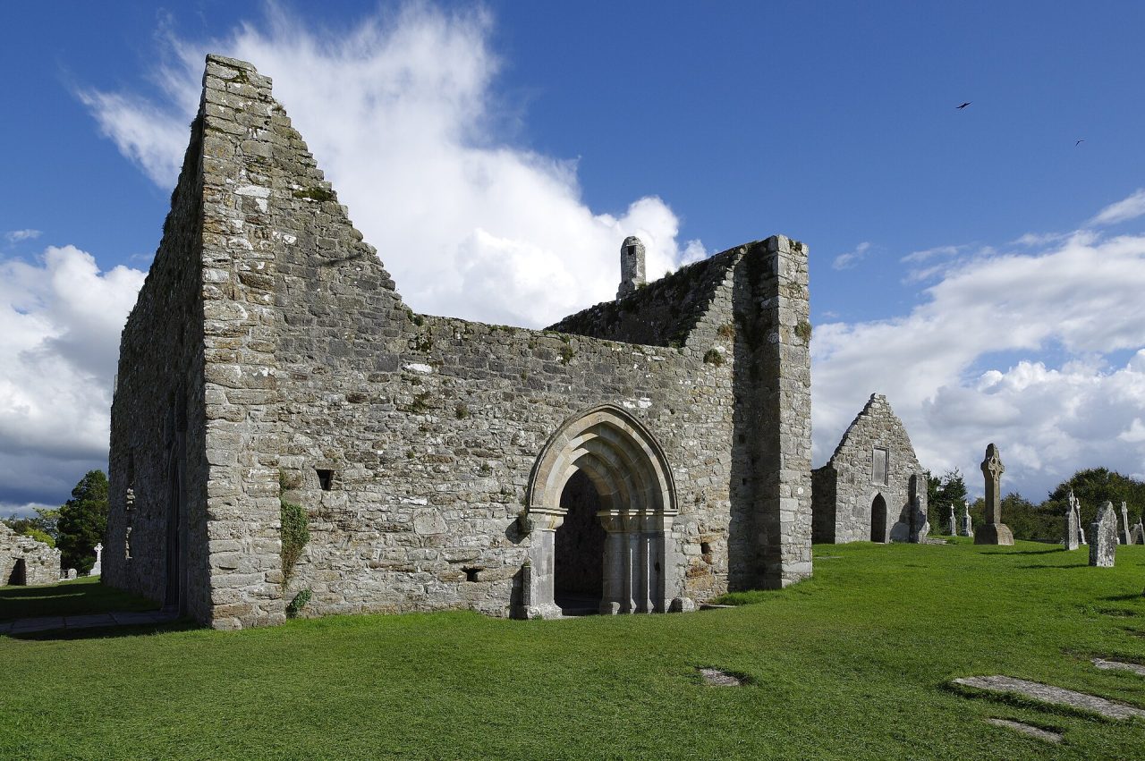 The doorway and walls of Clonmacnoise Cathedral opening toward the monastic ruins and green Shannon landscape.