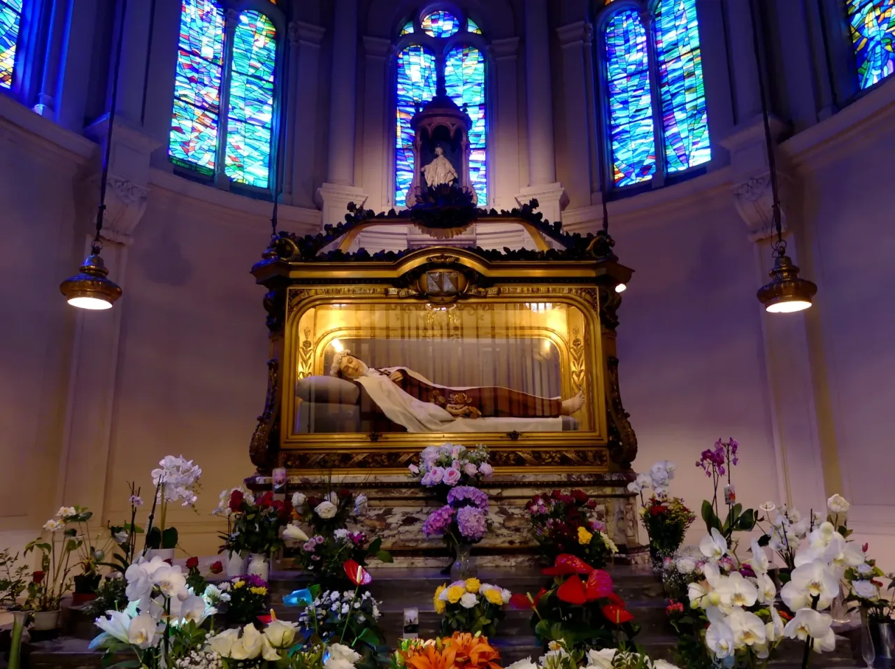 The chasse of Saint Therese in the chapel of the Carmel of Lisieux, a gilded reliquary set beneath a carved canopy.
