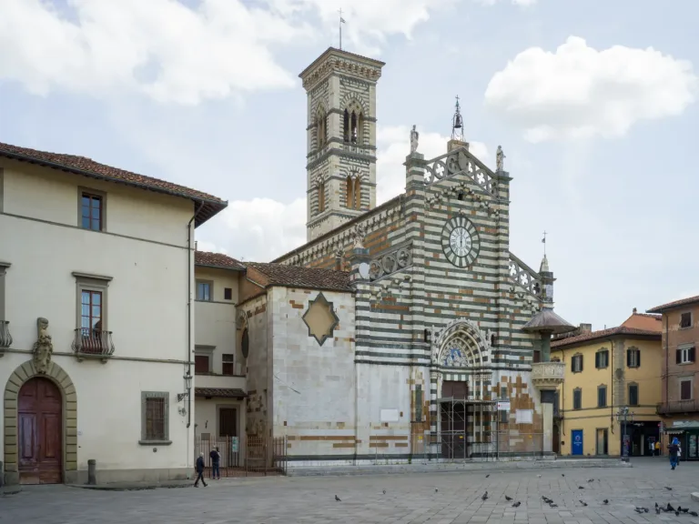 The striped marble facade of Prato Cathedral with its outdoor pulpit on the corner.