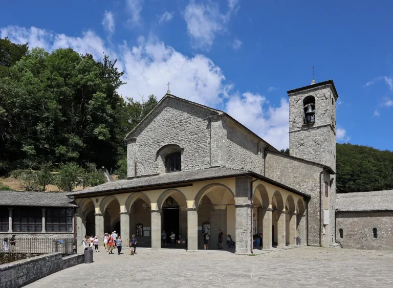 The church and portico of the Franciscan sanctuary of La Verna on its wooded ridge.