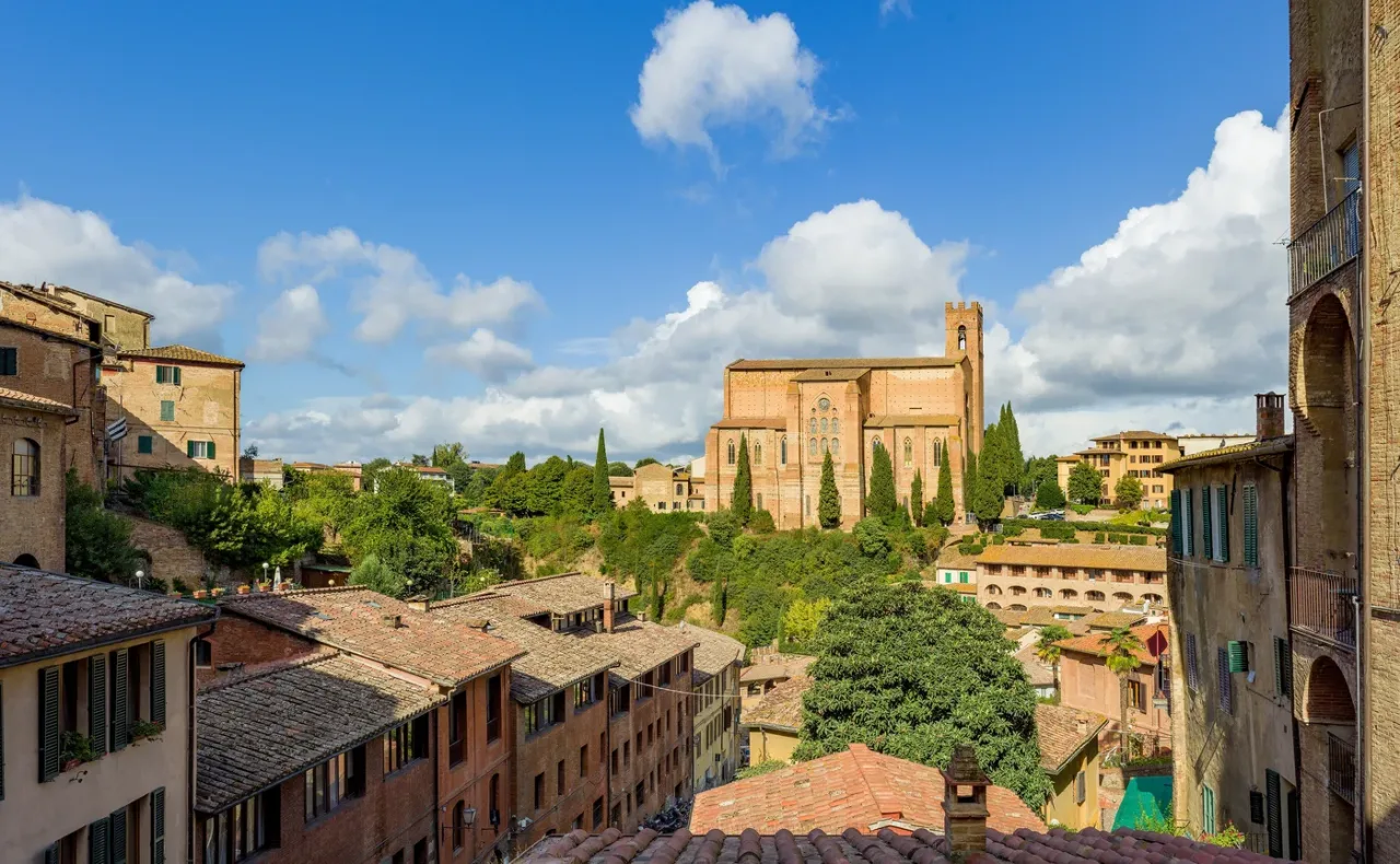 The Basilica of San Domenico rising in brick above the rooftops of Siena.