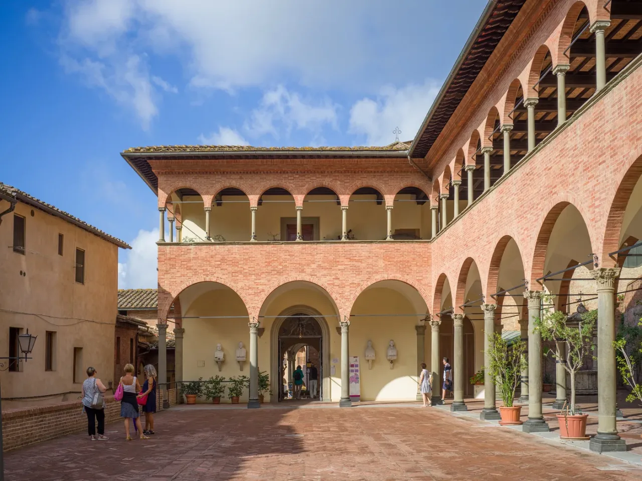 The brick portico and open courtyard of the Sanctuary of Saint Catherine in Siena.