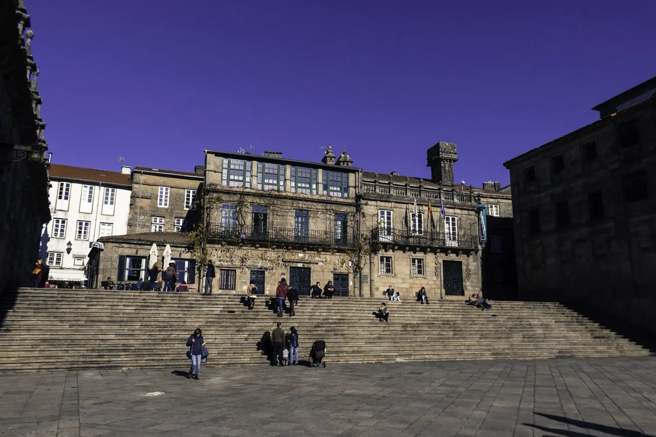 The Praza da Quintana in Santiago de Compostela, its broad flight of granite steps rising toward the long blank wall of the San Paio monastery.